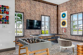 a game room with a foosball table and a tv