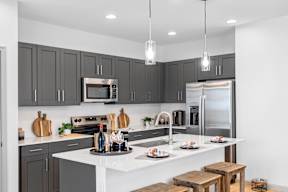 an open kitchen with a large island and stainless steel appliances
