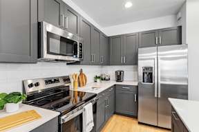 a kitchen with stainless steel appliances and black cabinets