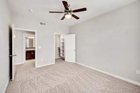 a bedroom with a ceiling fan and a closet