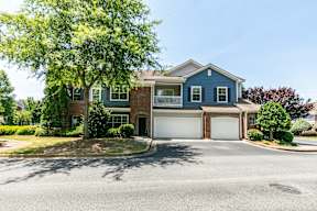 A two-story house with a garage and a driveway.