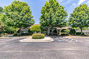 A roundabout with a building in the background and trees on the sides.