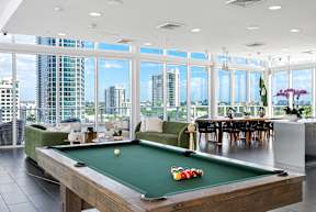 A pool table in a room with a view of the city.