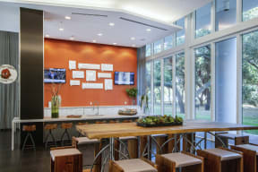 a kitchen with a wooden table and chairs and large windows