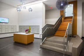 a view of the lobby of a building with stairs and a desk with a plant