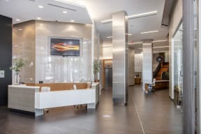 the lobby of a building with a white reception desk and a large glass wall
