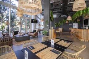 a restaurant with wicker tables and chairs and large windows