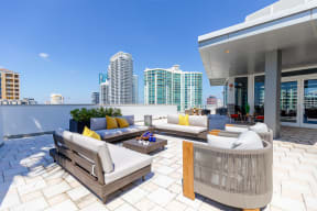 a terrace with couches and chairs and a city in the background