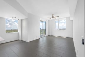 an empty living room with white walls and a ceiling fan