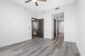 an empty living room with white walls and a ceiling fan