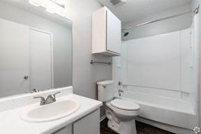 A white bathroom with a sink, toilet and bathtub.