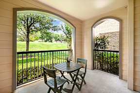 a patio with a table and chairs on a balcony