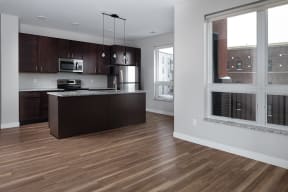 an open kitchen and living room with a large window  at RoCo Apartments, Fargo, ND