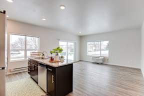 A kitchen with a black countertop and a dishwasher.