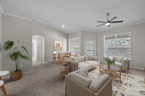 an open living room and dining room with couches and chairs and a ceiling fan