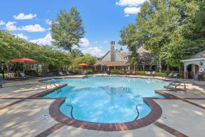 a swimming pool with trees and a house in the background