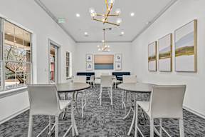 A conference room with a table, chairs, and pictures on the wall.