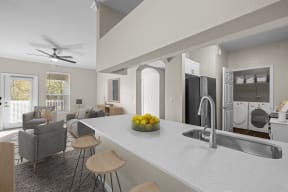 an open kitchen and living room with a counter and a sink