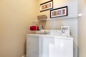 A white washing machine with a red towel on top of it.