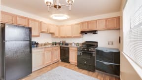 a kitchen with black appliances and wooden cabinets at Courthouse Green Apartments, Chesterfield , VA 23832