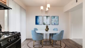 a dining room with a table and chairs and a kitchen with a stove at Courthouse Green Apartments, Chesterfield 