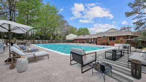 a backyard with a pool and furniture and a house at Courthouse Green Apartments, Virginia, 23832