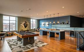 A room with a pool table and a bar.