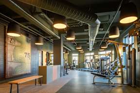 A gym with a bench, weights, and exercise equipment.