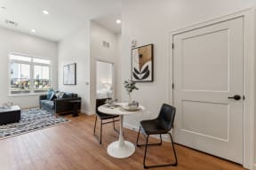 an open living room with white walls and wooden floors and a white door