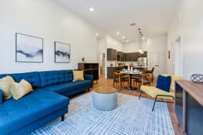 a living room with a blue couch and a table with chairs