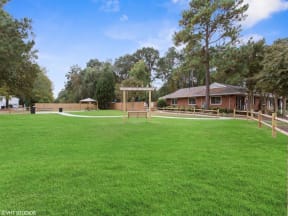 a large grassy area with a swing set and a building in the background at Courthouse Green Apartments, Virginia, 23832