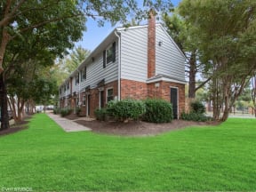 a white building with a brick chimney and green grass in front of it Chesterfield