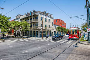 A street view with a red tram on the right and a building with a sign that says "The".