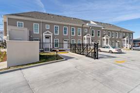 a large apartment building with a driveway and a parking lot