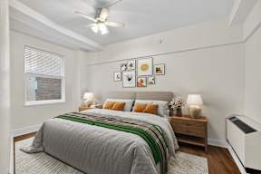 A bedroom with a bed, nightstands, and pictures on the wall.