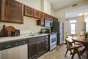 A kitchen with dark wood cabinets and stainless steel appliances.