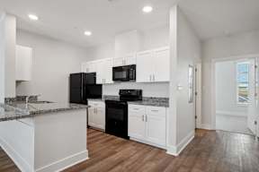 Grove Place I kitchen with white cabinets and black appliances
