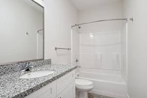 a bathroom with a shower sink and toilet and a mirror