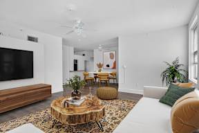 A living room with a white couch and a wooden coffee table.