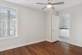 a living room with a large window and a ceiling fan