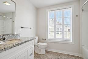 a bathroom with a toilet and a sink and a window