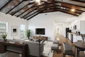 a living room with white walls and a ceiling with wooden beams