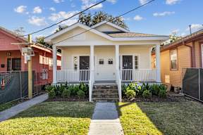 Grove Place II small white house with a porch and a front yard.