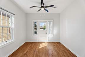 Grove Place II room with a ceiling fan and wooden flooring.