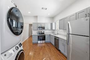 Grove Place II modern kitchen with stainless steel appliances and wooden floors.
