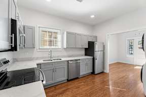 Grove Place II modern kitchen with wooden floors and stainless steel appliances.
