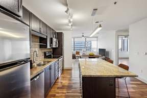 A modern kitchen with dark wood cabinets and stainless steel appliances.
