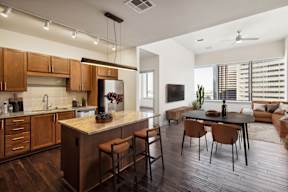 A modern kitchen with wooden cabinets and a bar area.
