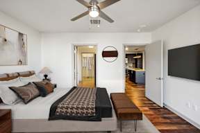 A bedroom with a large bed and a ceiling fan.