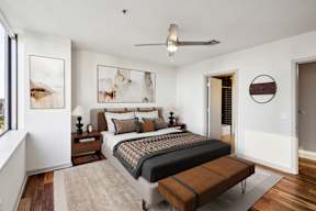 A bedroom with a large bed and a ceiling fan.
